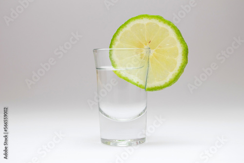 Tequila shot with lime on white