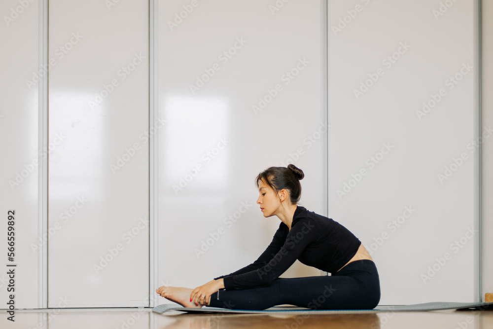 Fototapeta premium person sitting on the floor and doing yoga