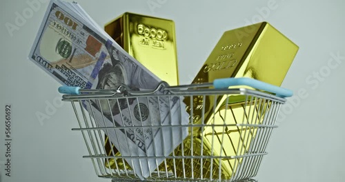 Buying gold. two ingots of 999.9 Fine Gold and dollars rotates in a grocery basket.