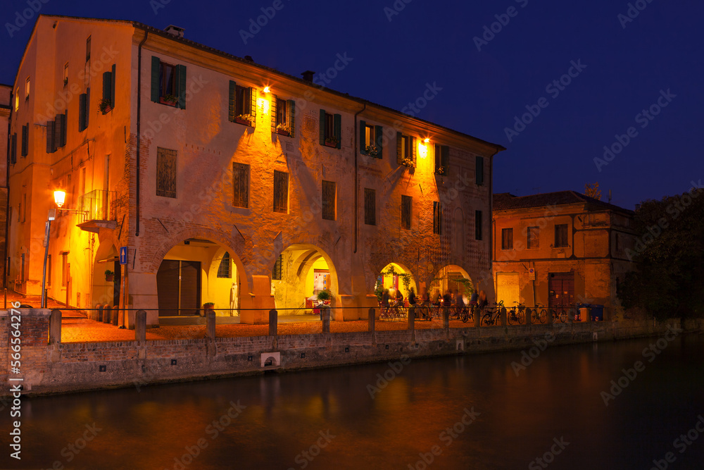 Restaurant terrace at the riverside in the night . Street terrace at Sile river in Treviso 