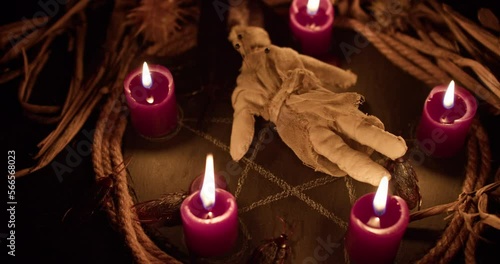 Occultist dripping hot wax on voodoo doll, magic rituals, black spell, horror.
