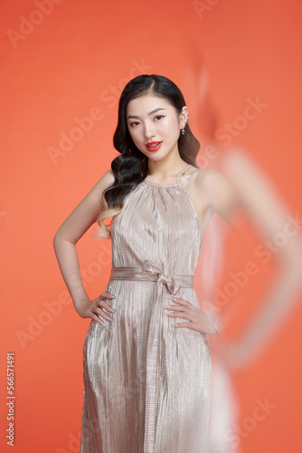 Studio portrait of tall girl in party attire posing on isolated background.