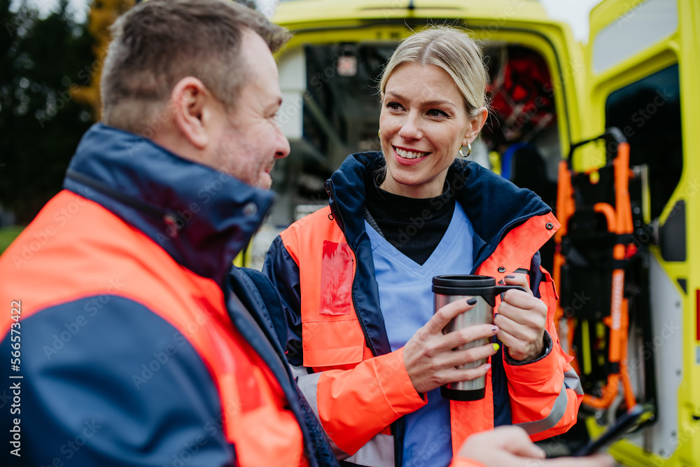 Rescuers having break in front of ambulance car, talking and drinking coffee. Rescuers having break in front of ambulance car, talking and drinking coffee.