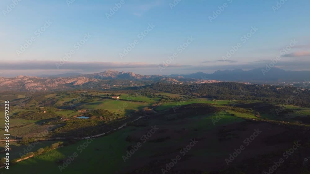 Green countryside with rocky mountains at sunset Green countryside with rocky mountains at sunset