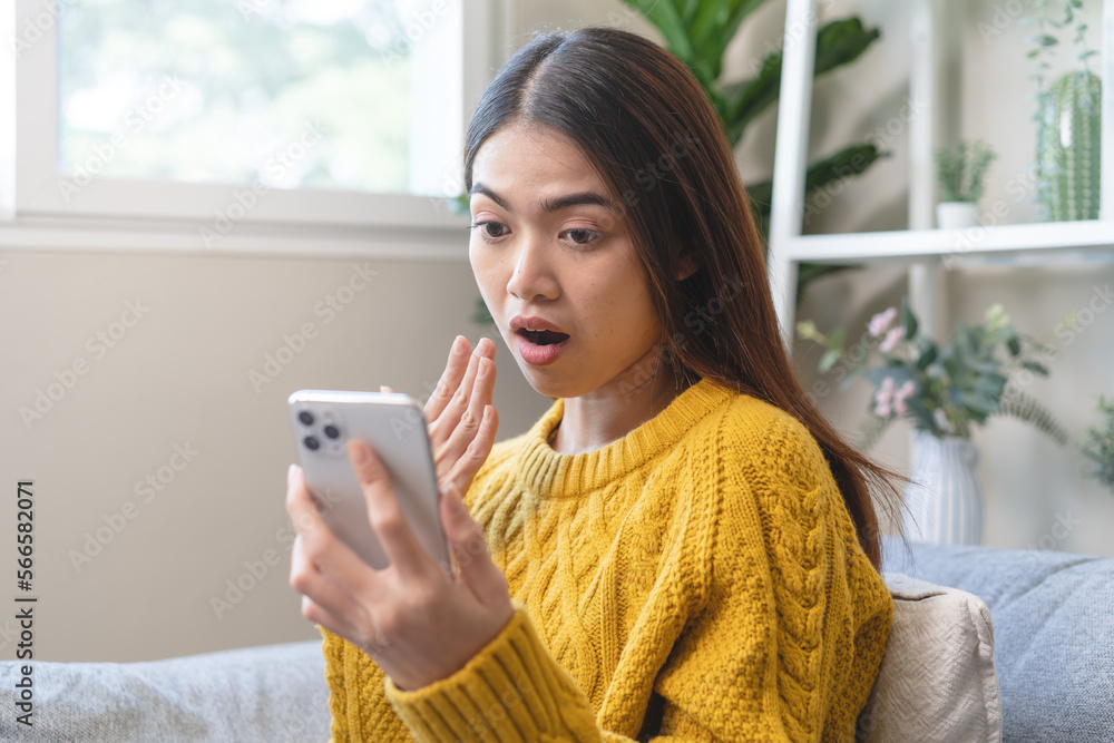 Young asian woman have shocked face expression during read bad news in mobile phone Young asian woman have shocked face expression during read bad news in mobile phone