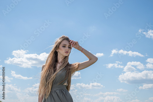 Beautiful girl on a background of a summer cloudy sky.
