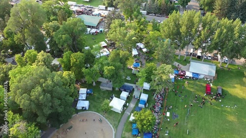 Aerial drone shot looking down at tents set up in small town park for festival photo