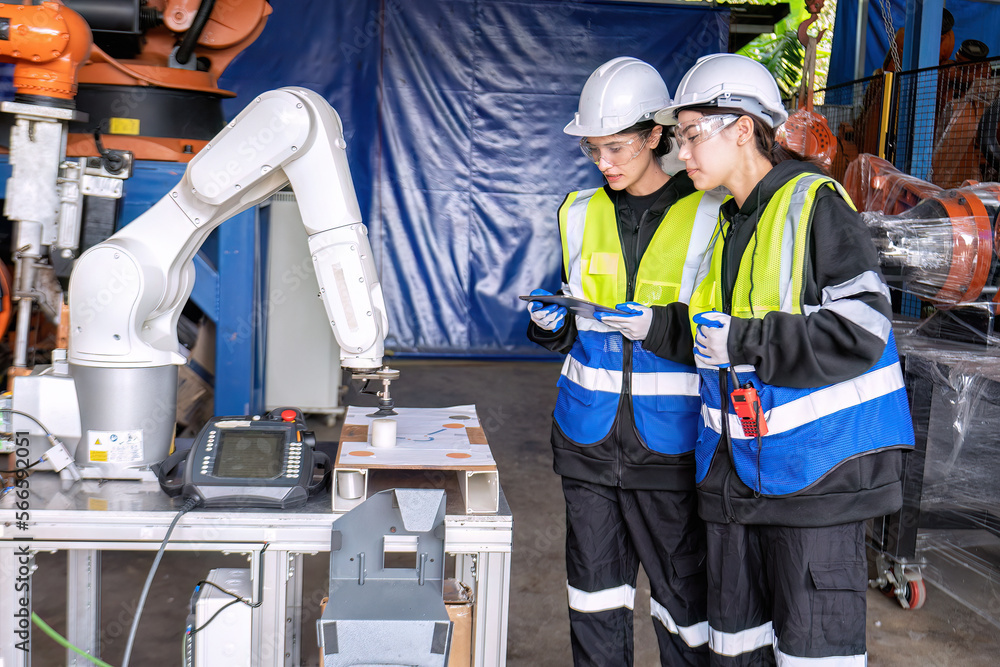 Women engineer team together at work in modern advanced robot welding machine sell service factory Women engineer team together at work in modern advanced robot welding machine sell service factory