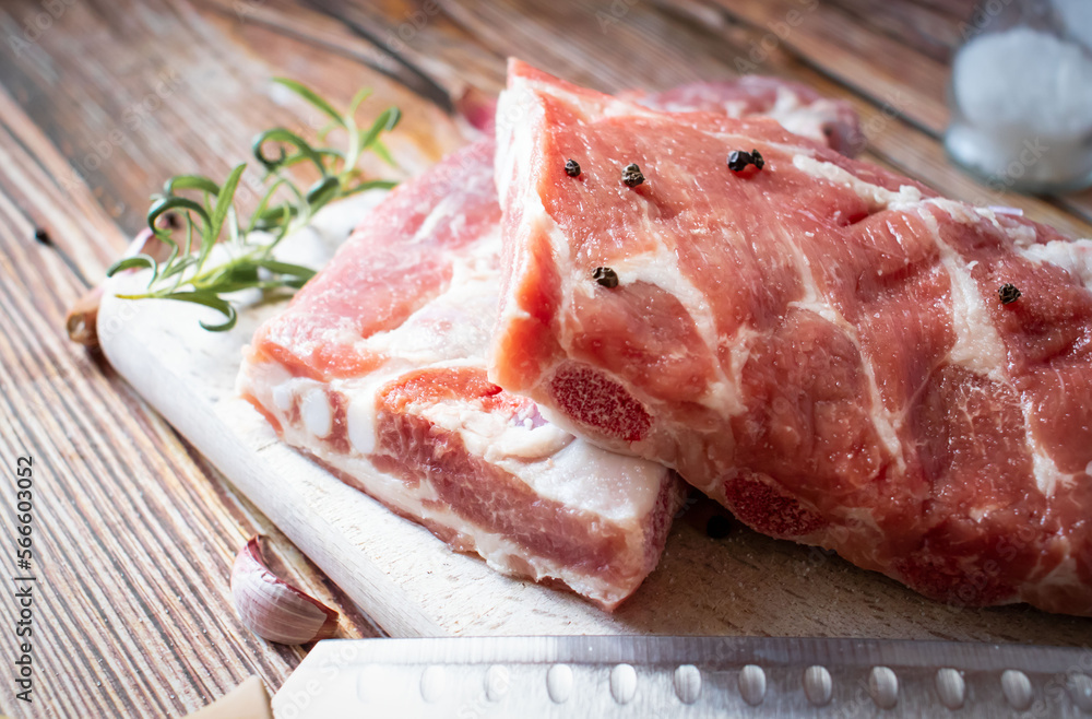 Raw pork ribs with rosemary and black pepper. on a wooden background
