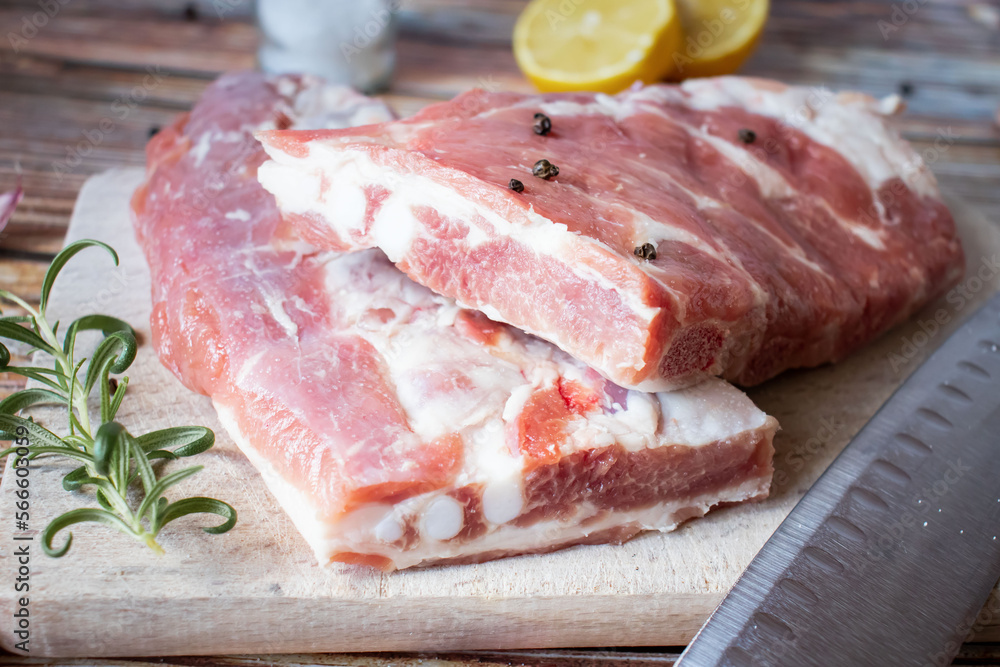 Raw pork ribs with rosemary and black pepper. on a wooden background Raw pork ribs with rosemary and black pepper. on a wooden background