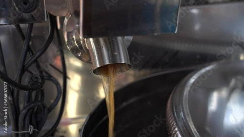Maple syrup production.  Boiling maple syrup pouring out of boiler into stainless steel container.   Producing maple syrup. Footage.