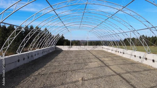 Drone view of the first stages of the construction of a commercial dome. Steel structure. Hoop building. Agricultural storage. Early stages of the construction of a Fabric building. Dome. Trusses.