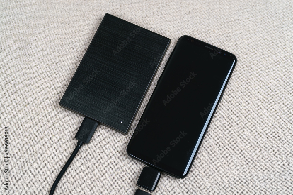 Black external hard drive and black mobile smartphone Black external hard drive and black mobile smartphone