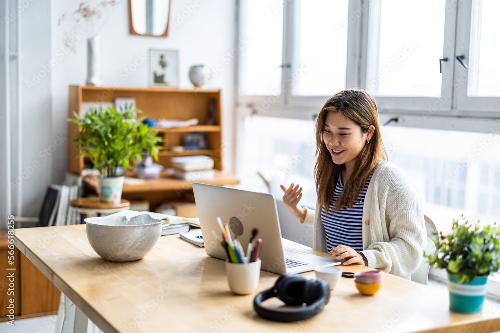 Young woman sitting at desk working on laptop
Young woman sitting at desk working on laptop