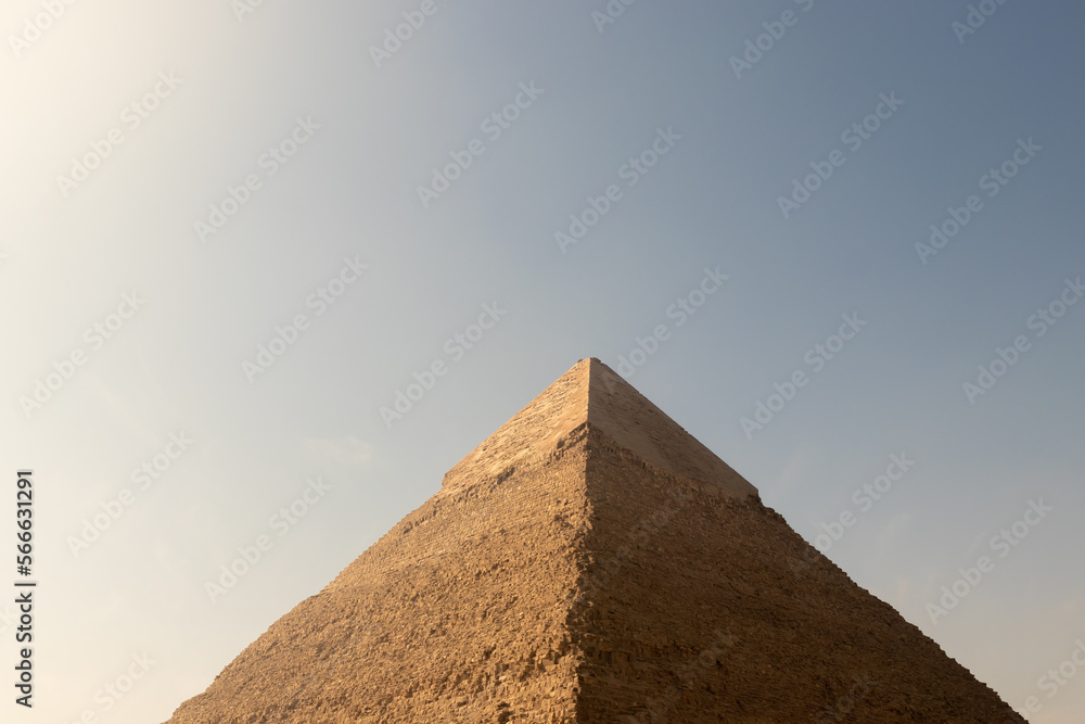 Close up cropped view of Giza great pyramid in the centre of the photo with copy space under blue clear sky and no people Close up cropped view of Giza great pyramid in the centre of the photo with copy space under blue clear sky and no people