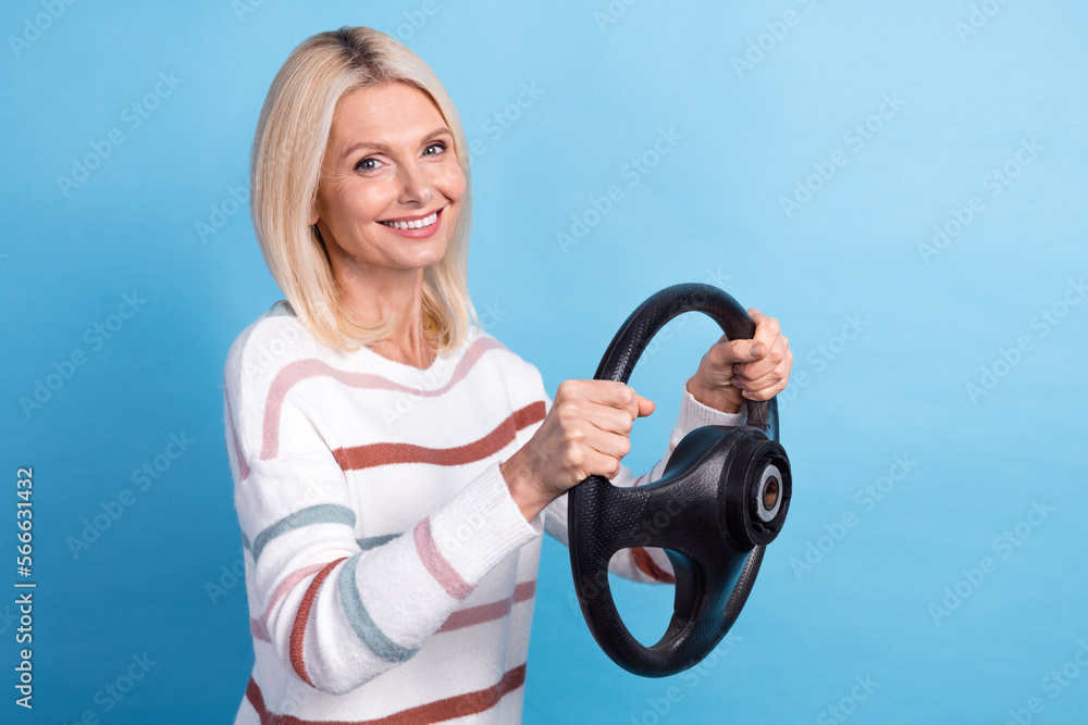 Photo of sweet shiny lady wear striped pullover smiling driving car empty space isolated blue color background Photo of sweet shiny lady wear striped pullover smiling driving car empty space isolated blue color background