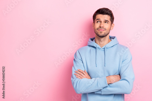 Portrait of attractive minded man arm crossed look empty space interesting proposition special offer isolated on pink color background © deagreez