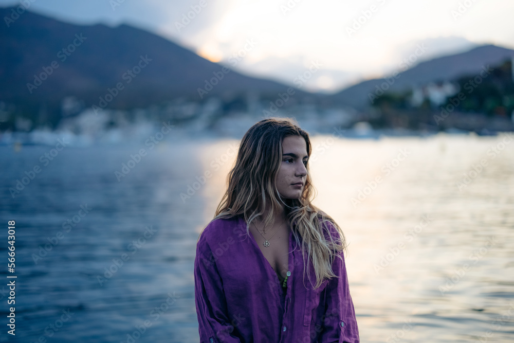 Calm young woman sitting in sea water and looking away Calm young woman sitting in sea water and looking away