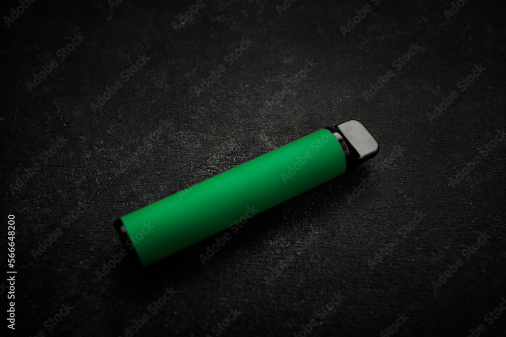 Disposable electronic cigarette of green color, on gray background Disposable electronic cigarette of green color, on gray background