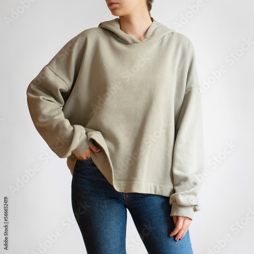 Woman wearing green hoodie and blue jeans isolated on white background	