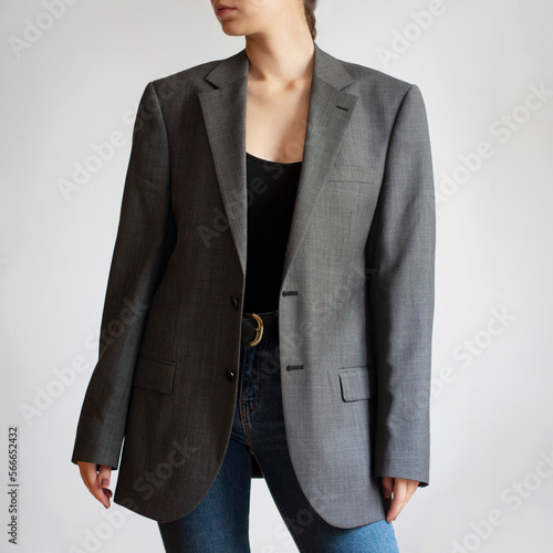 Woman wearing oversized blazer and blue jeans isolated on white background