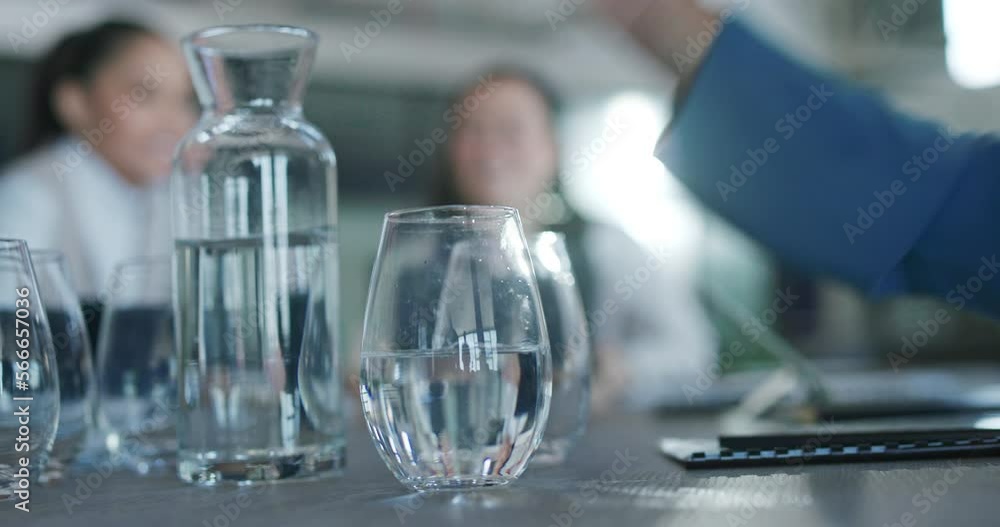 Business people, hands and pouring glass of water for meeting, discussion or planning on a table. Hand of thirsty employee filling cup half full on office desk for hydration in preparation for speech Business people, hands and pouring glass of water for meeting, discussion or planning on a table. Hand of thirsty employee filling cup half full on office desk for hydration in preparation for speech