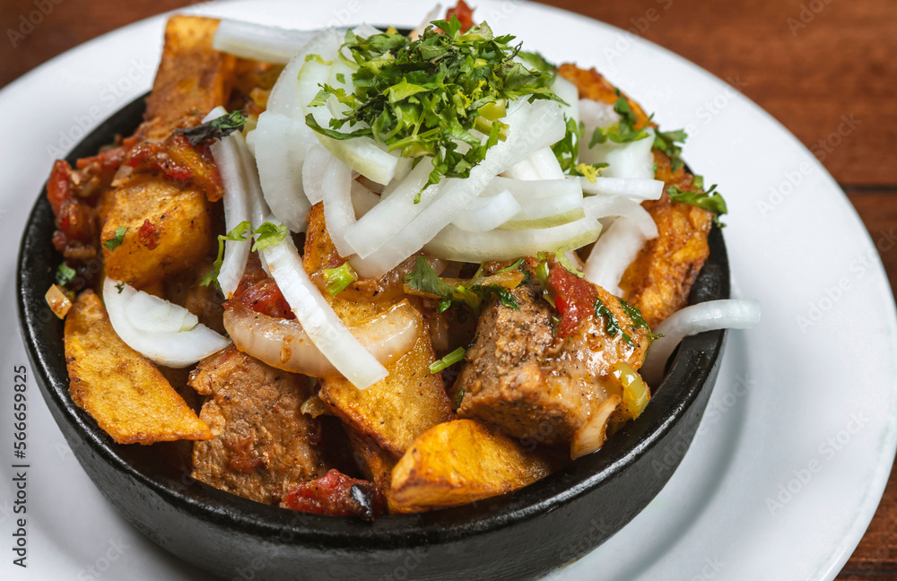 Fototapeta premium Beef stew with potatoes, carrots and herbs on black background with copy