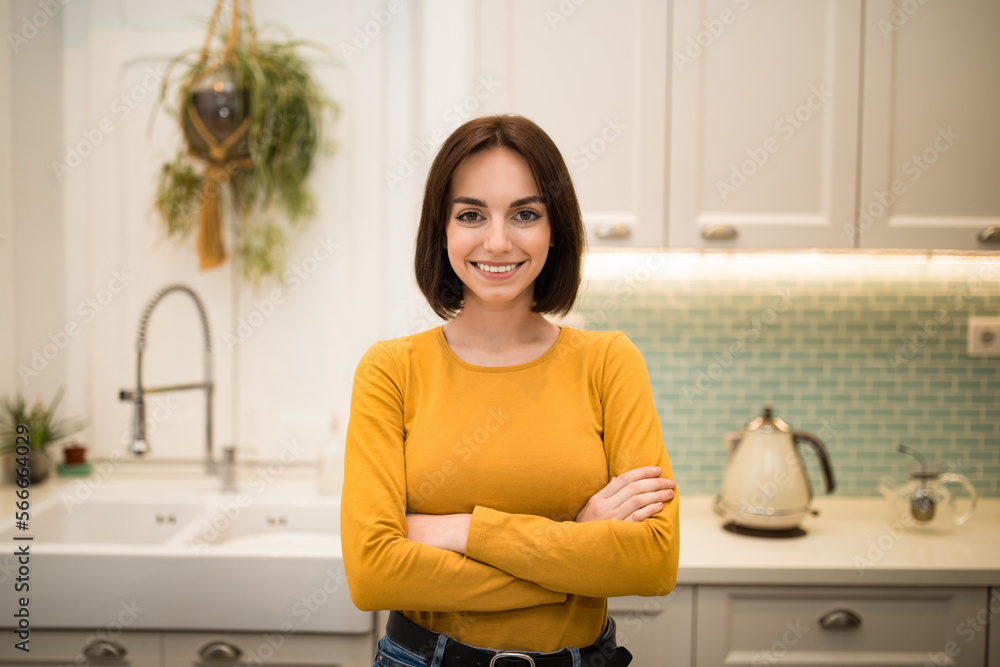 Candid photo of cheerful young lady posing in kitchen