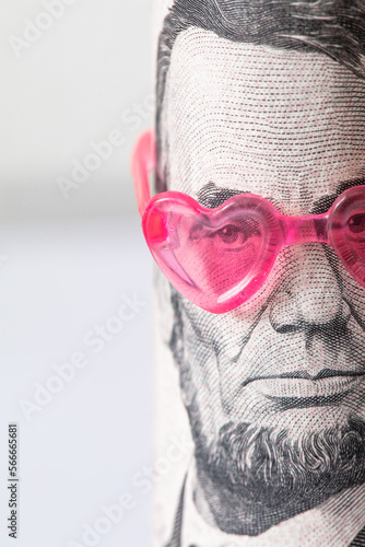 Abraham Lincoln from US 5 dollar banknote in pink heart sunglasses