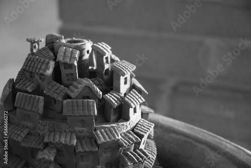 La foto mostra un piccolo castello in terracotta realizzato con abilità da un artigiano. Il castello è dettagliato e presenta elementi architettonici come torri, finestre, porte e merlatura.  photo