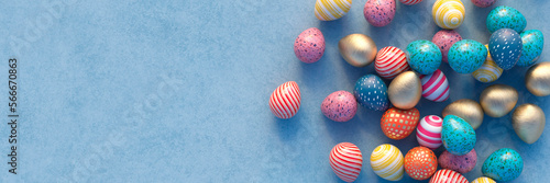 Multi coloured Easter eggs on a blue table panoramic 3d render