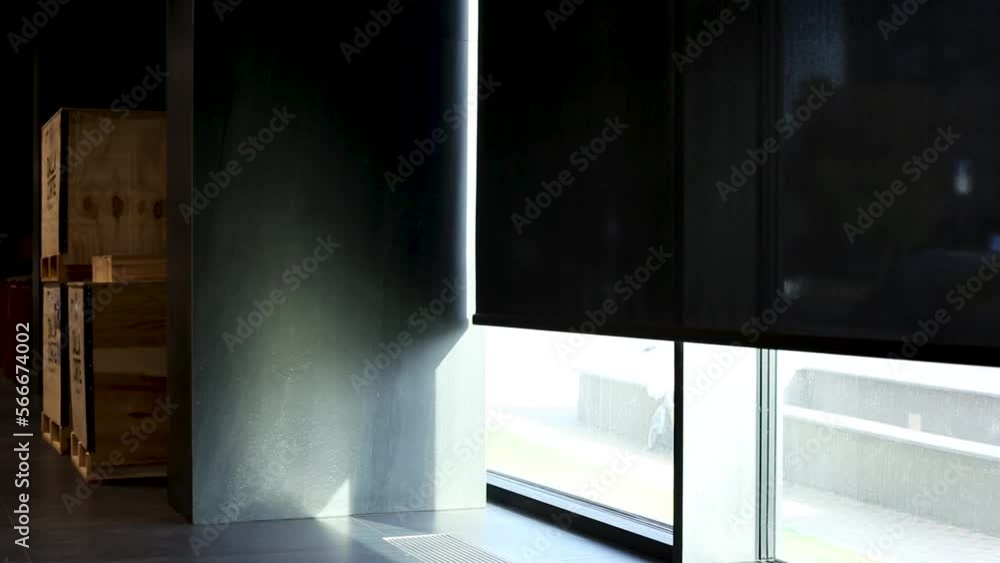 Motorized roller blinds opening up on the window in the cafe. Solar shades black color in the urban style interior. Screen material for automated roller blinds. Motorized roller blinds opening up on the window in the cafe. Solar shades black color in the urban style interior. Screen material for automated roller blinds.
