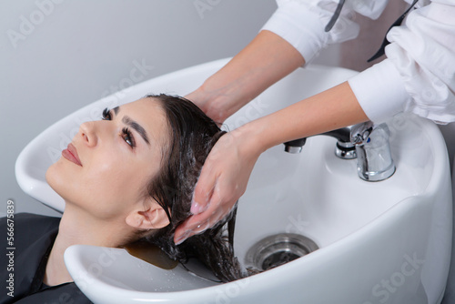 professional hairdresser washing hair of young woman in beauty salon. close up of woman's hair in beauty salon, hairstyle concept