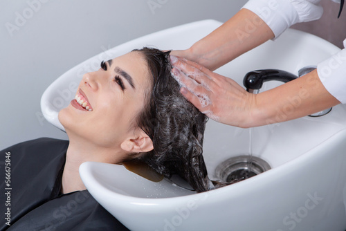 professional hairdresser washing hair of young woman in beauty salon. close up of woman's hair in beauty salon, hairstyle concept