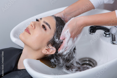 professional hairdresser washing hair of young woman in beauty salon. close up of woman's hair in beauty salon, hairstyle concept