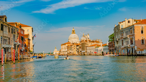 Panoramic view over Grand Canal, near beautiful Basilica di Santa Maria della Salute and the historical center of Venice at sunny day and blue sky.