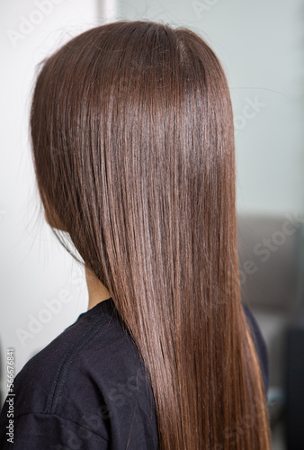 A straight healthy brunette hair that has undergone the hair straightening procedure. straight, shiny and healthy brunette hair