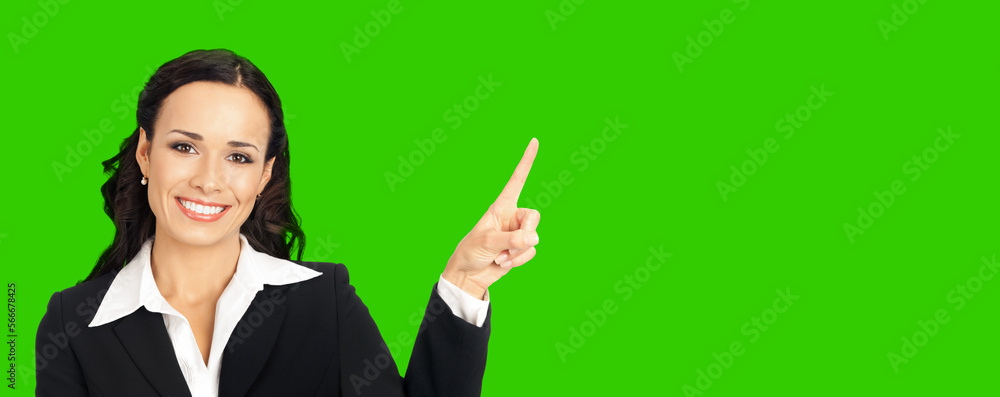 Young happy smiling woman in black confident suit, showing pointing at copy space. Business concept. Brunette businesswoman. Green chroma key background. Young happy smiling woman in black confident suit, showing pointing at copy space. Business concept. Brunette businesswoman. Green chroma key background.