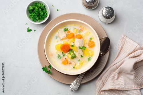 Creamy fish chowder soup in bowl on concrete background