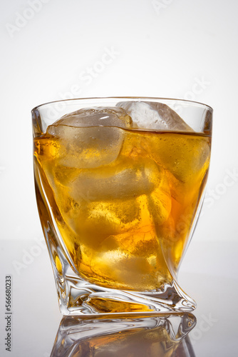 Whiskey alcoholic cocktail with ice, close-up, light background