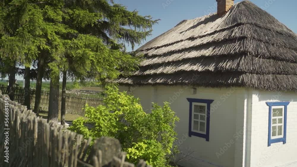 A rustic house with a chimney and white walls, standing next to a forest. A clear summer day. A rustic house with a chimney and white walls, standing next to a forest. A clear summer day.