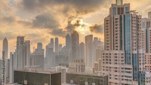 Dubai skyscrapers with golden sunset over business bay district .