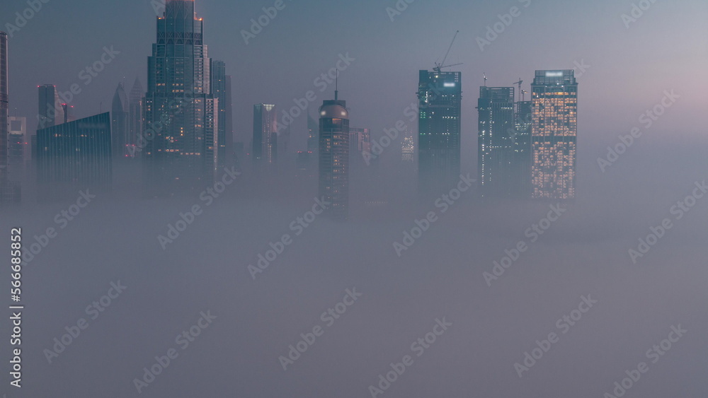 Aerial view morning fog covered Dubai International Financial Centre district night to day
