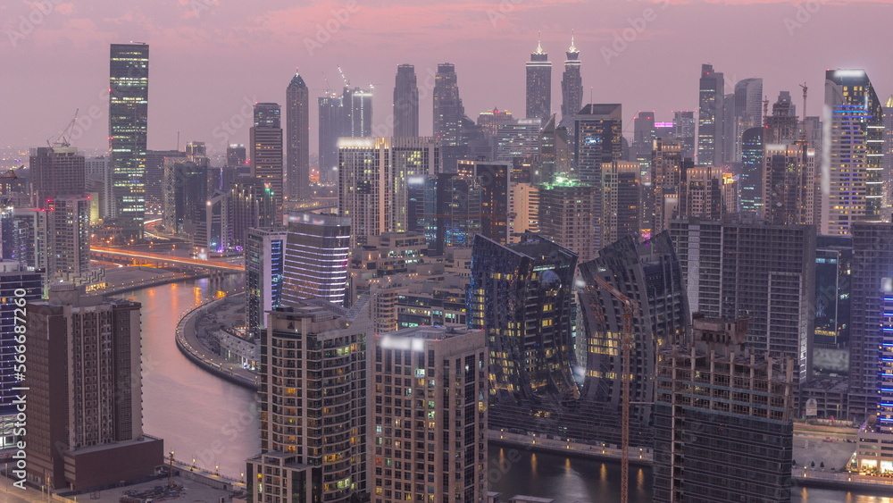 Skyline with modern architecture of Dubai business bay towers day to night . Aerial view