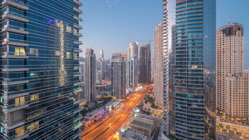 View of the Dubai Marina and JBR area and the famous Ferris Wheel aerial night to day