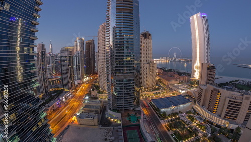 Panoramic view of the Dubai Marina and JBR area and the famous Ferris Wheel aerial night to day