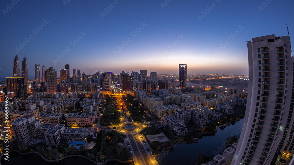 Skyscrapers in Barsha Heights district and low rise buildings in Greens district aerial night to day .