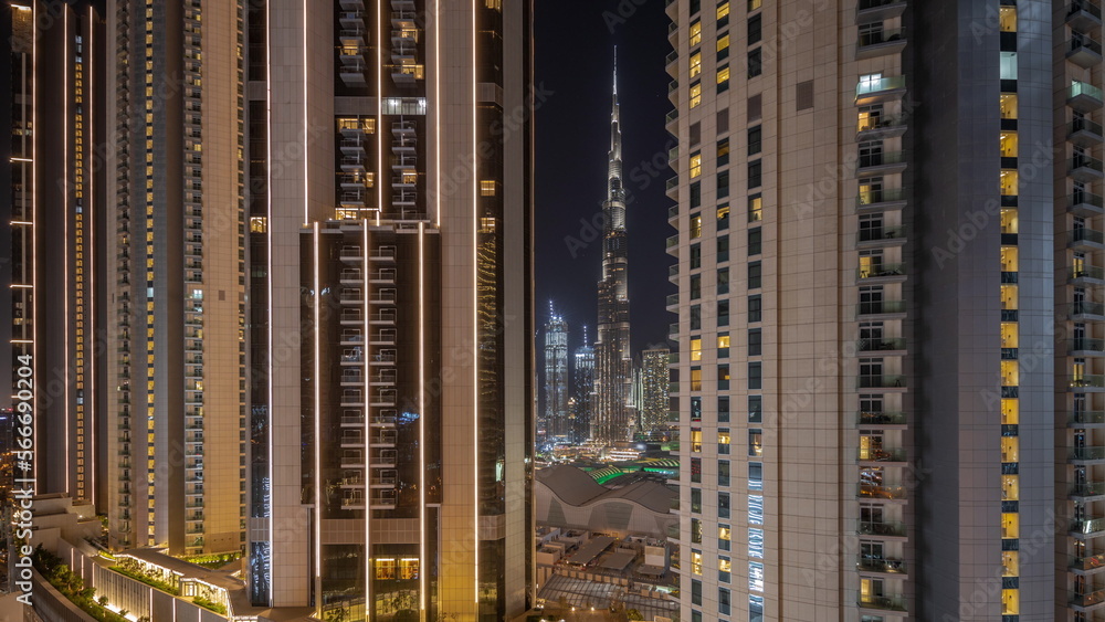 Tallest skyscrapers in downtown dubai located on bouleward street near shopping mall aerial night .