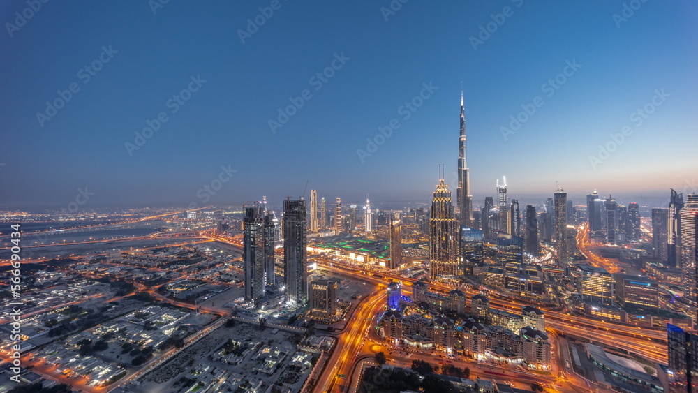 Aerial view of tallest towers in Dubai Downtown skyline and highway day to night .