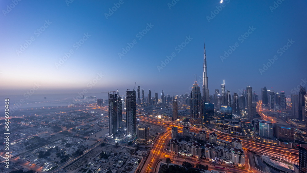 Aerial view of tallest towers in Dubai Downtown skyline and highway night to day .